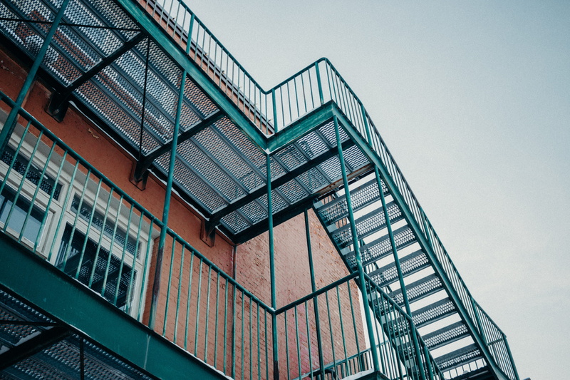 jar, handrail, banister, fire escape, city, building, tree, staircase, steps and staircases, no people, office building exterior, glass - material, day