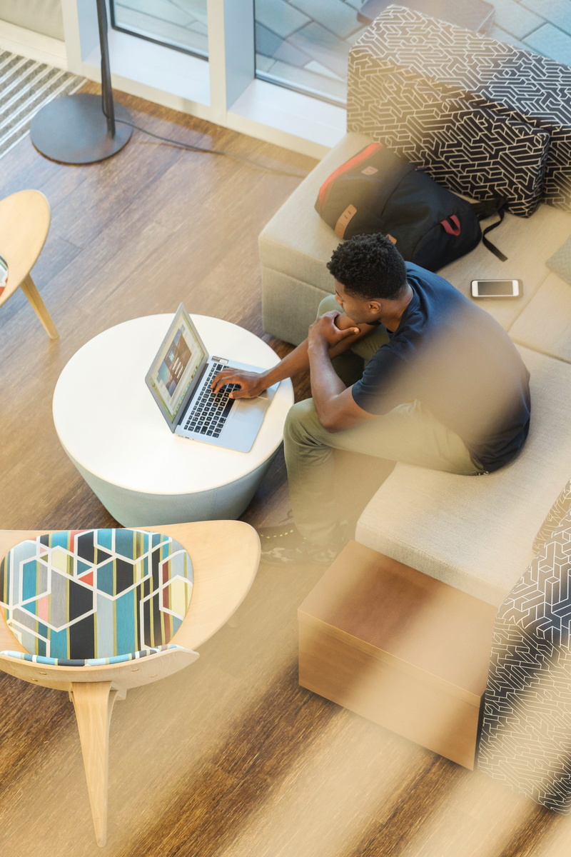 lifestyles, pants, man, working, laptop, men, business, holding, sitting, macbook, adult, rucksack, real people, table, males, couch, high angle view, people