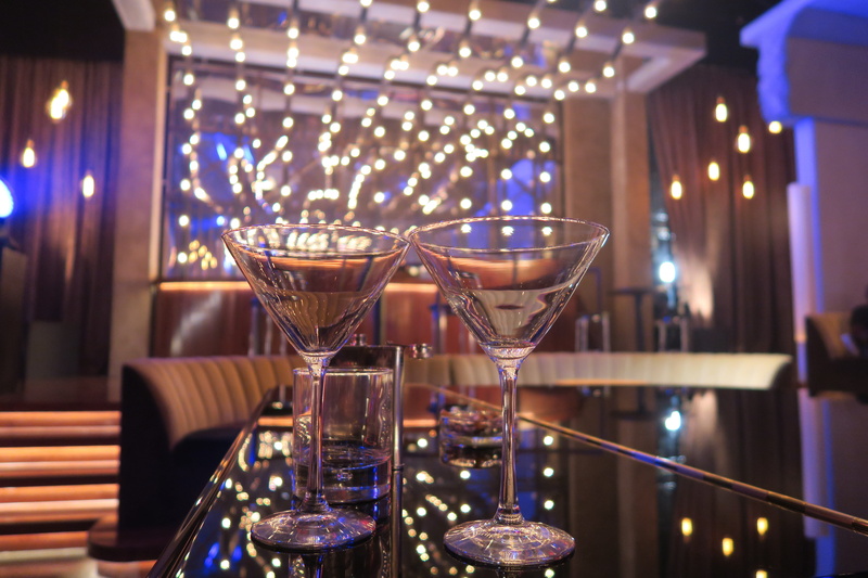 drinking glass, nightclub, illuminated, purple, bar counter, no people, focus on foreground, table, celebration, martini glass, alcohol, dance, glass - material