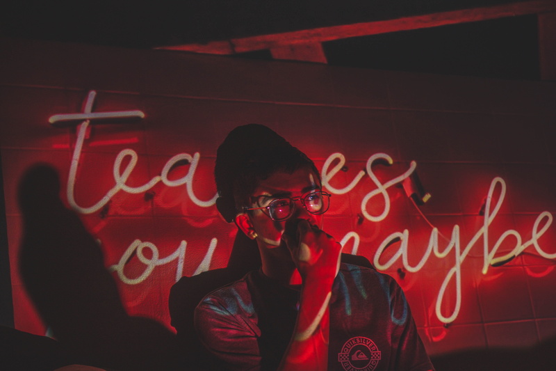 nightlife, real people, young adult, neon, dim, text, mid adult, signage, lights, lifestyles, front, light, red, night, man, sign, woman, indoors, standing