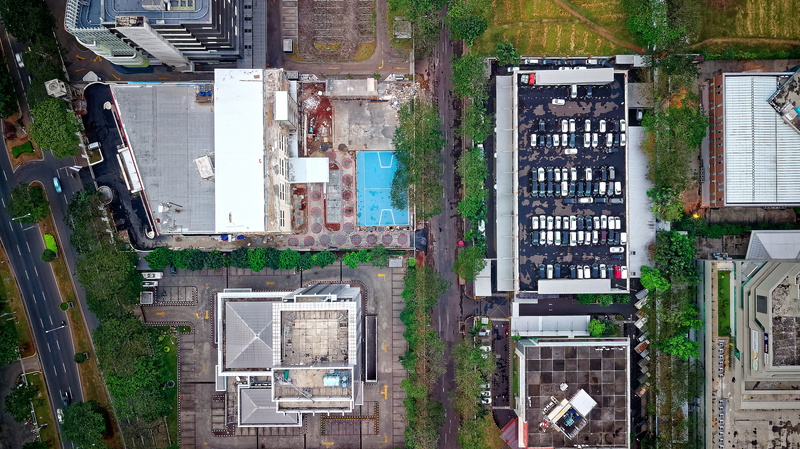 built structure, photography, outdoors, aerial, text, pavement, buildings, communication, no people, high angle view, windows, building, parking area, tree