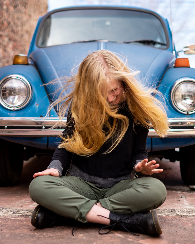 sitting, front view, full length, day, one person, outdoors, transportation, lifestyles, beetle, front, land vehicle, teenager, mode of transportation