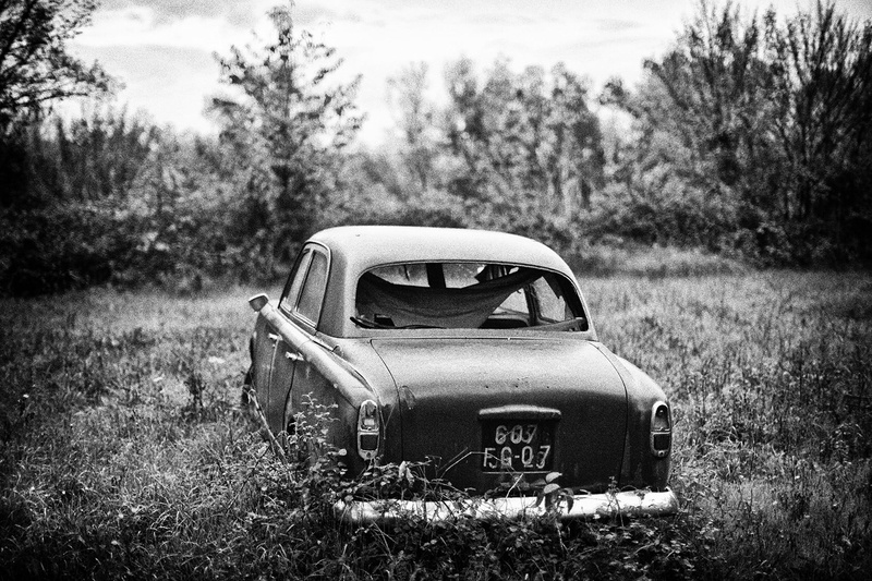 photography, obsolete, mode of transportation, wreck, land, day, outdoors, 720P, no people, focus on foreground, grayscale, abandoned, nature, field, damaged