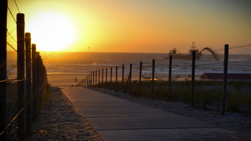 frame, horizon over water, bright, orange color, sunlight, fence, no people, path, tranquility, wooden, direction, water, black, sky, outdoors, tranquil scene