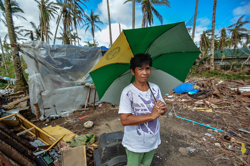 wear, garbage, standing, lifestyles, green, outdoors, hurricane, three quarter length, trash, land, leisure activity, woman, palm trees, front view, near
