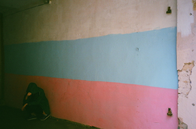 hood - clothing, indoors, relaxation, blue, modern, multi colored, lifestyles, hood, leaning, hoody sweater, day, graffiti, real people, wall - building feature
