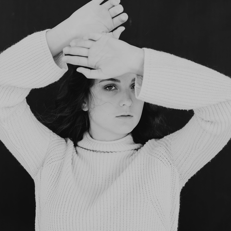 arm, clothing, 2K, black background, photography, teenager, hood, front view, female, sweater, woman, person, grayscale, sleeve, headshot, turtleneck