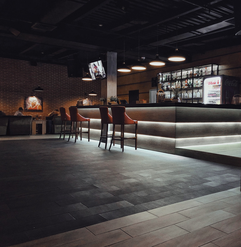 bar counter, wood, person, rear view, floor, men, human, illuminated, food, pub, people, table, seat, full length, ceiling, waiting, indoors, couch, chair