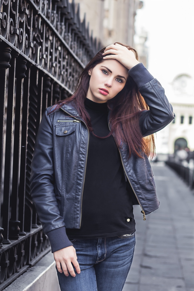 street portrait, real people, explorer, one person, beautiful woman, leather jacket, contemplation, long hair, gate, young adult, young woman, street photography