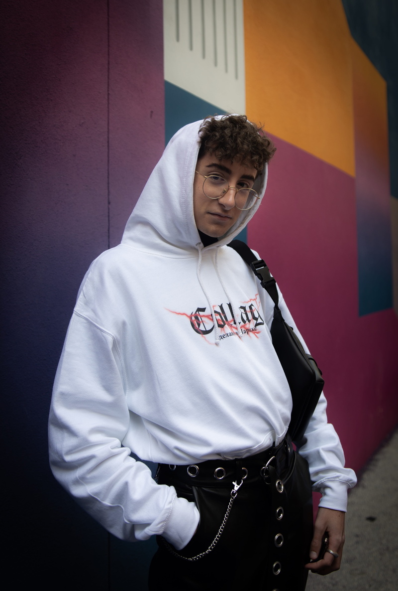 hood, multicolored, waist up, apparel, standing, hoodie, person, man, leisure activity, near, shirt, human, inflatable, adolescence, flugelhorn, wall, long sleeve