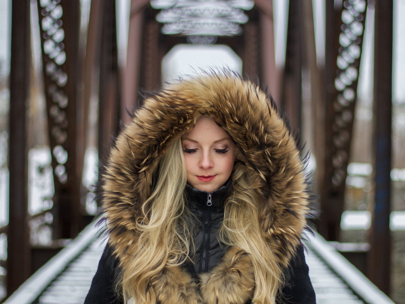 black jackets, winter coat, closed eyes, clothing, young adult, headshot, outdoors, one person, hairstyle, hood - clothing, jacket, blonde, fur coat, winter