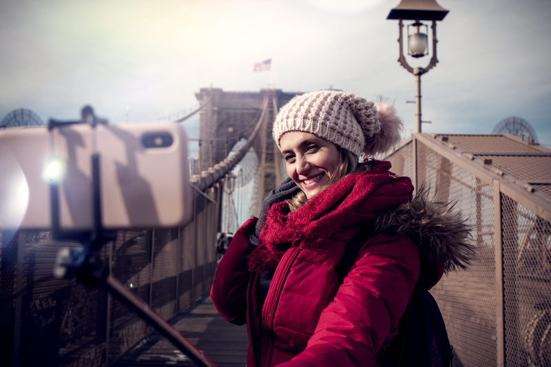 smiling, zip, phone, emotion, lifestyles, person, urban, architecture, winter, beanie, taking photo, jacket, knit hat, brookline bridge, cold temperature
