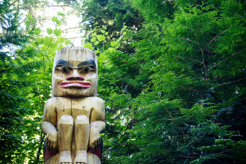 male likeness, outdoors, nature, craft, green color, sculpture, belief, 5K, religion, day, art and craft, forest, tiki, trees, representation, surrounded