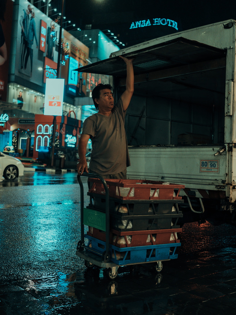 working, city life, teenager, young adult, human, land vehicle, metropolis, one person, lifestyles, men, leisure activity, building, full length, automobile
