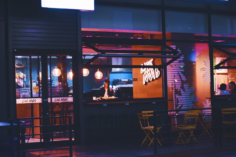 real people, cafe, nightlife, glass - material, illuminated, seat, architecture, business, restaurant, night, light, text, sitting, 2K, window, built structure