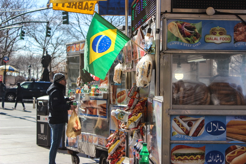 human representation, street, car, hot dogs, text, flag, motor vehicle, architecture, stall, food stand, hot dog stand, human, sign, mode of transportation