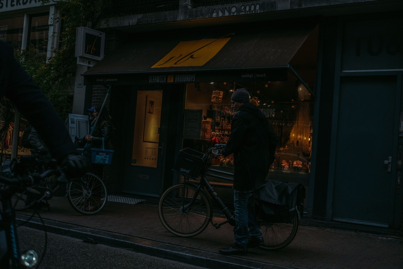 people, street, standing, real people, communication, bike, built structure, one person, architecture, bicycle, city, rear view, building exterior, store
