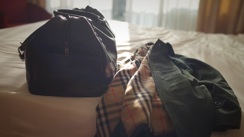 bag, clothing, hotel, luxury, real people, vuitton, close-up, travel, indoors, luggage, one person, casual clothing, bed, lifestyles, home interior, burberry