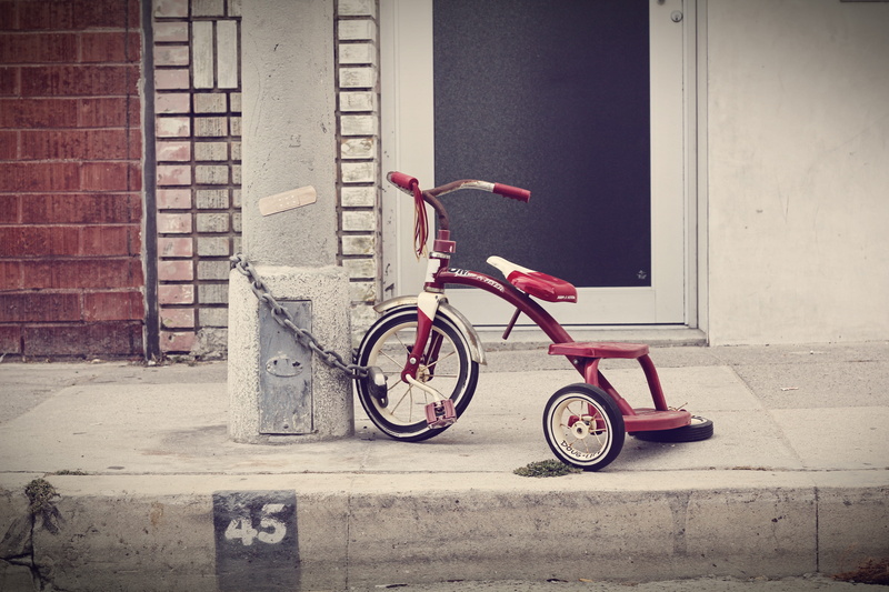 parking, three wheeler, brick, mode of transportation, sidewalk, bike, tricycle, wheels, day, bicycle, absence, locked, building exterior, land vehicle