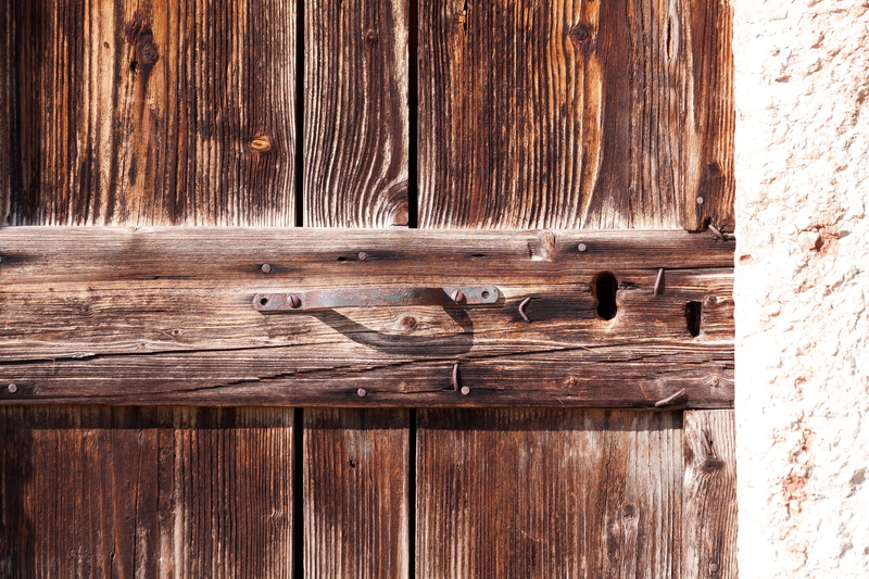 wood grain, day, sunlight, metal, western script, wooden, old door, surface, rustic, pattern, nails, rough, plank, backgrounds, wood, door, no people, stone