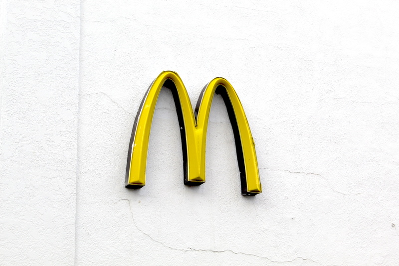 logo, day, copy space, built structure, mcdonald, choice, side by side, yellow, indoors, still life, wall - building feature, white color, variation, no people
