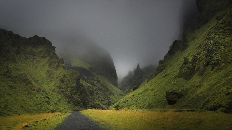 grass, no people, sky, non-urban scene, land, dark, landscape, green color, mist, idyllic, mountains, mountain, nature, green, dirt road, power in nature
