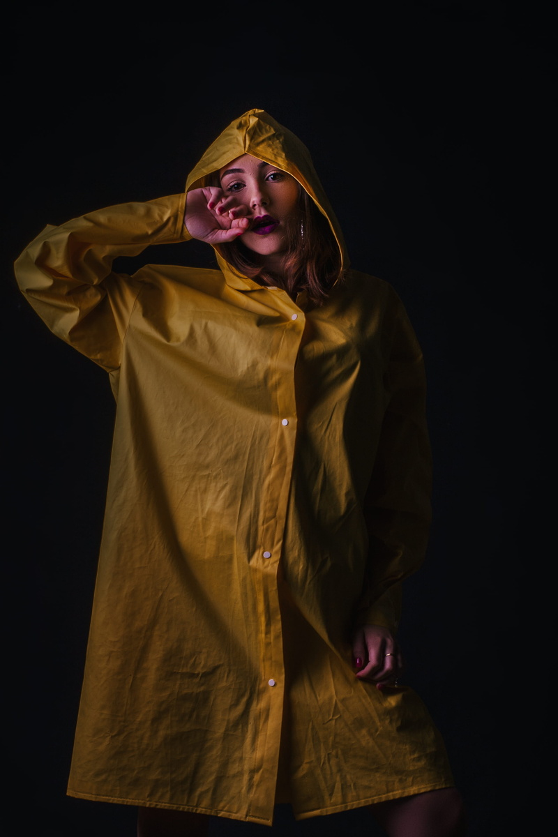 smiling, beauty, beautiful woman, one person, wearing, dark, black background, raincoat, adult, female, pretty, young adult, front view, three quarter length