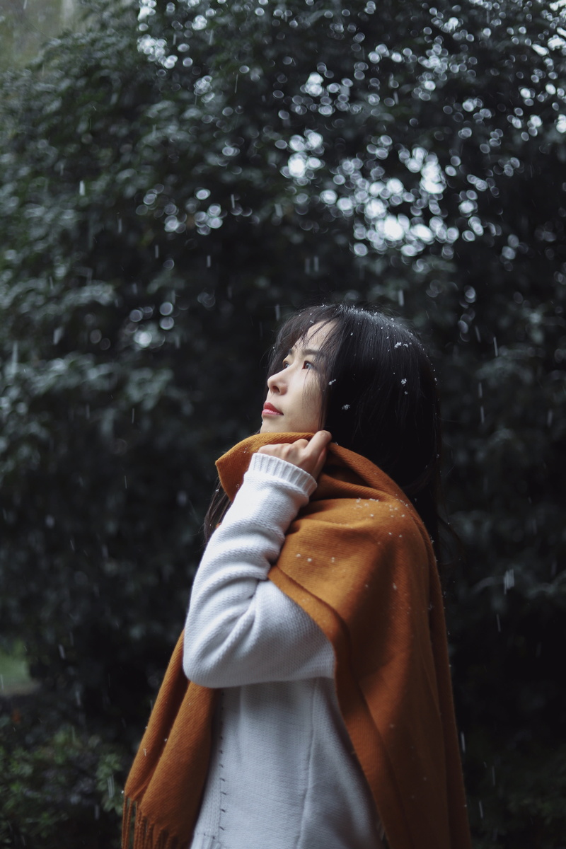 person, coat, tree, focus on foreground, plant, woman, apparel, women, day, young women, grey, white, sweater, looking away, cloak, 5K, lifestyles, overcoat