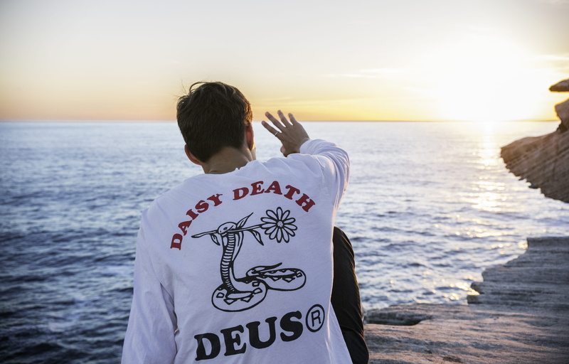 communication, shirt, bird, sleeve, water, one person, ocean, vest, sitting, text, rear view, horizon, horizon over water, clothing, right, human, near