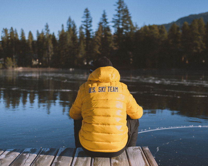 yellow, tree, ice skate, water, mountain, sunlight, plant, nature, lake, human, wood - material, dock, outdoor, whistler, coat, raincoat, security, person