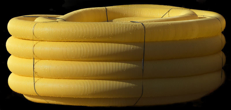 arts culture and entertainment, food and drink, drain pipe, yellow, spirituality, indoors, construction industry, studio shot, coiled, black background