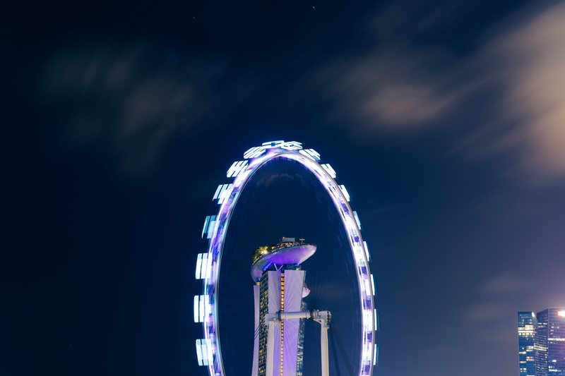 city, low angle view, skyscraper, 8K, no people, carnival, blue, amusement park, wheel, nature, motion, lighting, spoke, outdoors, cloud - sky, sky, night