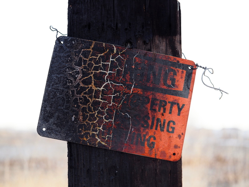 architecture, barbed wire, focus on foreground, coat rack, accessories, daytime, metal, old, signage, post, burned, warning, built structure, tree, 5K
