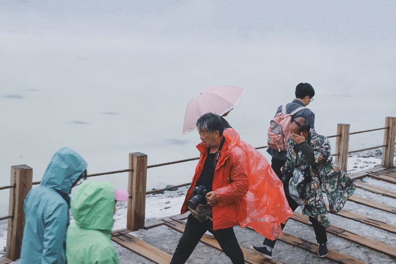 water, kimono, walking, leisure activity, bridge, togetherness, raincoat, canopy, military uniform, ocean, winter, umbrella, camera, wood - material, rain
