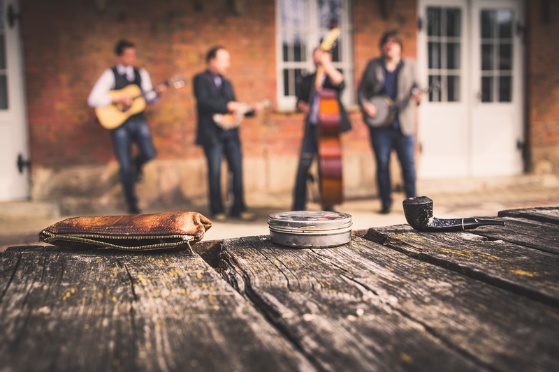 outdoors, day, band, gray, side view, bluegrass, incidental people, architecture, table, adult, black, casual clothing, acoustic, wood - material, full length