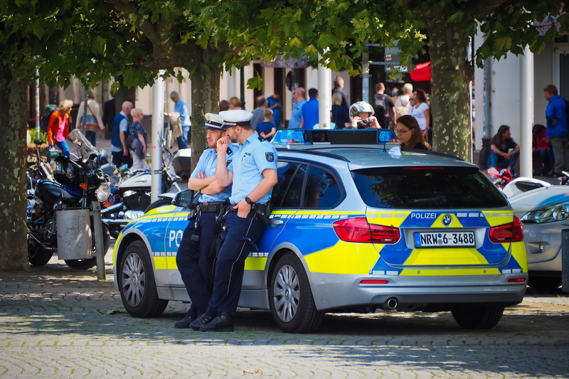 streetscape, mode of transportation, motor vehicle, city, scene, street, women, land vehicle, police force, real people, police, pavement, patrol car, downtown
