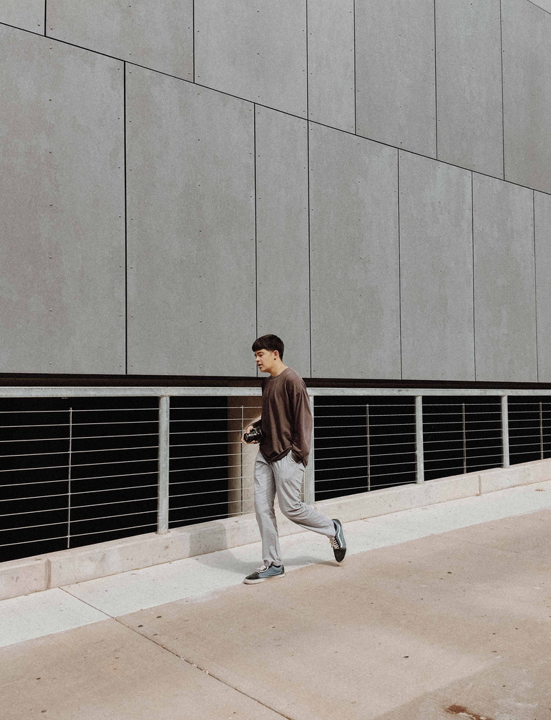 full length, architecture, leisure activity, young men, casual clothing, walking, sunlight, front view, real people, building, men, shirt, pavement, teenager
