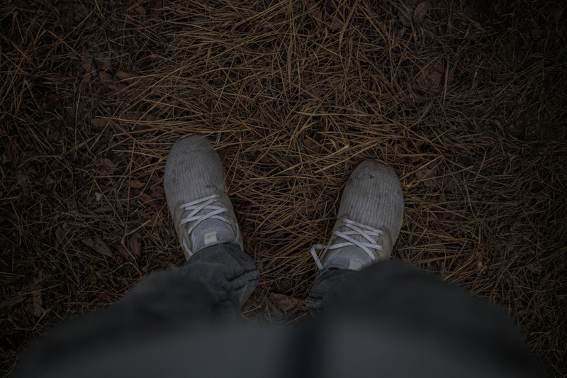 human leg, directly above, running shoe, apparel, human limb, boot, ankle, soil, puddle, human, personal perspective, bandage, ground, human body part