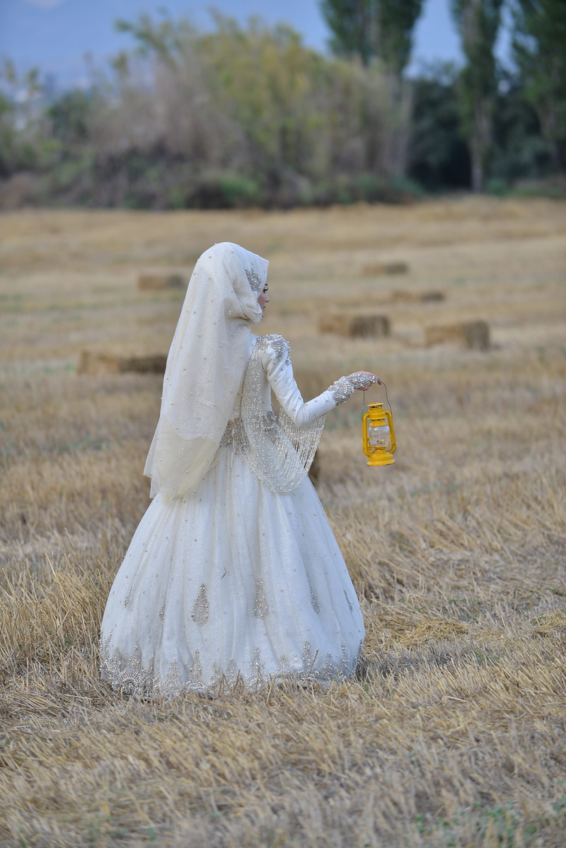 lifestyles, woman in white, holding, nature, focus on foreground, lamp, brown field, standing, kerosene, brown, costume, adult, land, day, one person, light