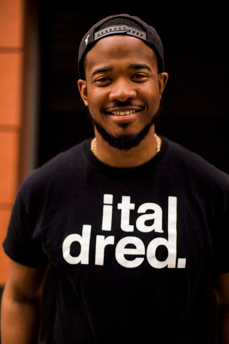 standing, one person, black, waist up, shirt, focus on foreground, cap, indoors, men, happiness, young adult, facial expression, man, fashion, front view