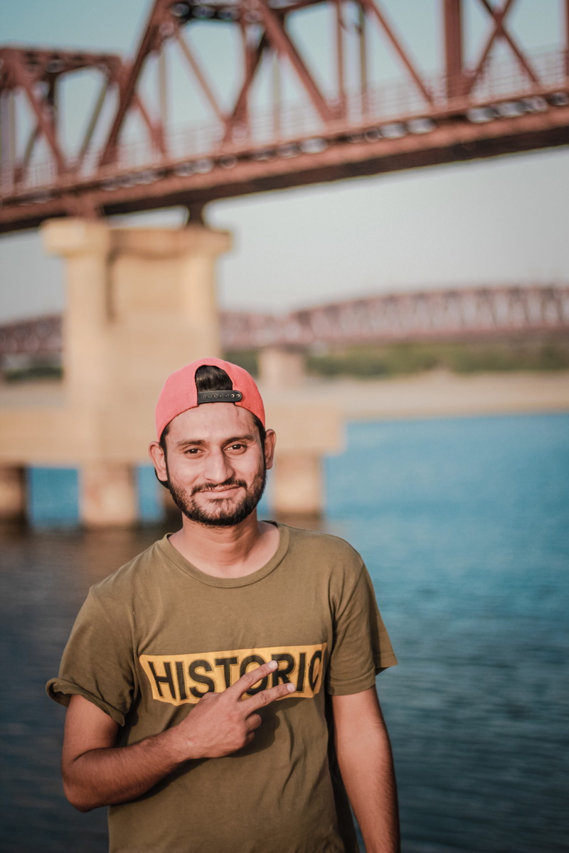 looking, architecture, young men, waist up, snapback, casual clothing, beside, red, connection, taking, smiling, facial expression, looking at camera, cap