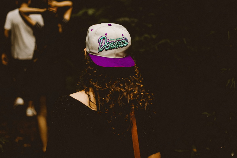 focus on foreground, white, women, leisure activity, wearing, cap, fitted, long hair, purple, oh, portrait, lady, headshot, standing, rear view, brimmed