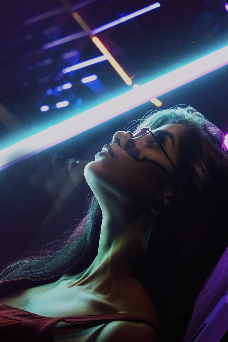 headshot, lying, blur, festival, portrait, illuminated, performance, hairstyle, low angle view, neon lights, hair, city, nightclub, adult, one person, beautiful woman