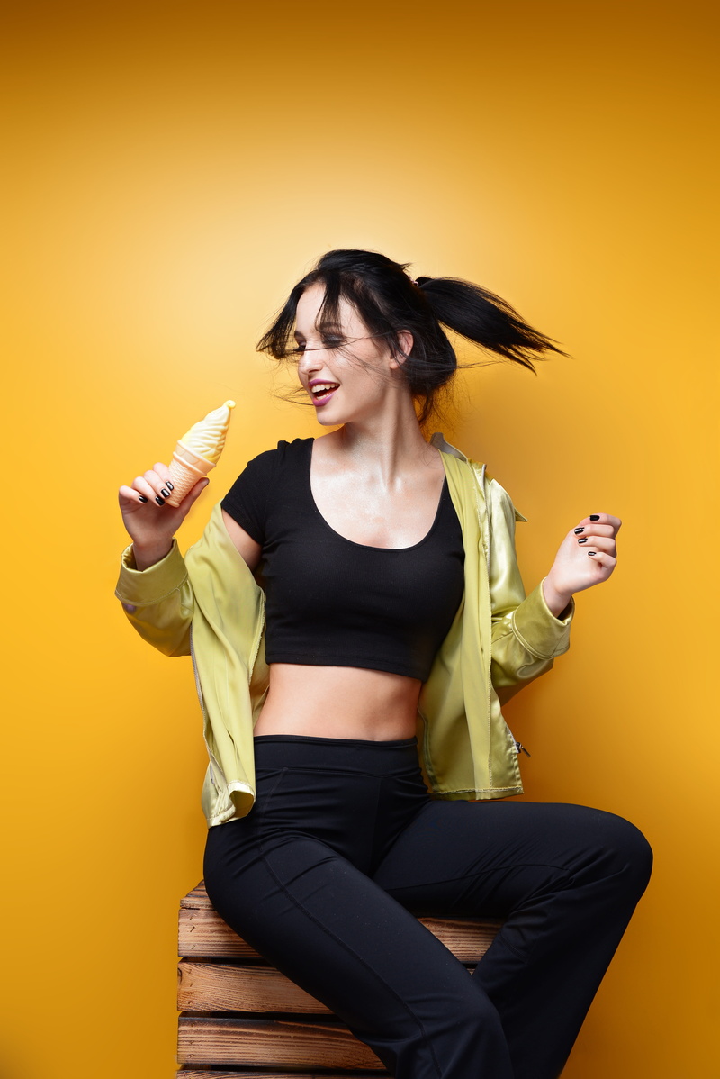 active, yellow background, smiling, background, young adult, holding, posing, beautiful woman, yellow, casual clothing, woman, hairstyle, wooden crate