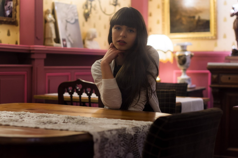 model, selective focus, women, beautiful woman, waist up, looking at camera, sitting, looking at viewer, hand on chin, casual clothing, contemplation, portrait
