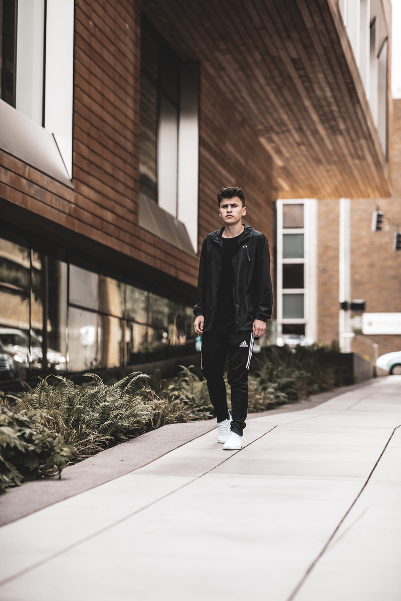 footpath, flooring, runway, suit, building exterior, jacket, day, standing, man, coat, footwear, 5K, overcoat, shirt, female, real people, black, woman