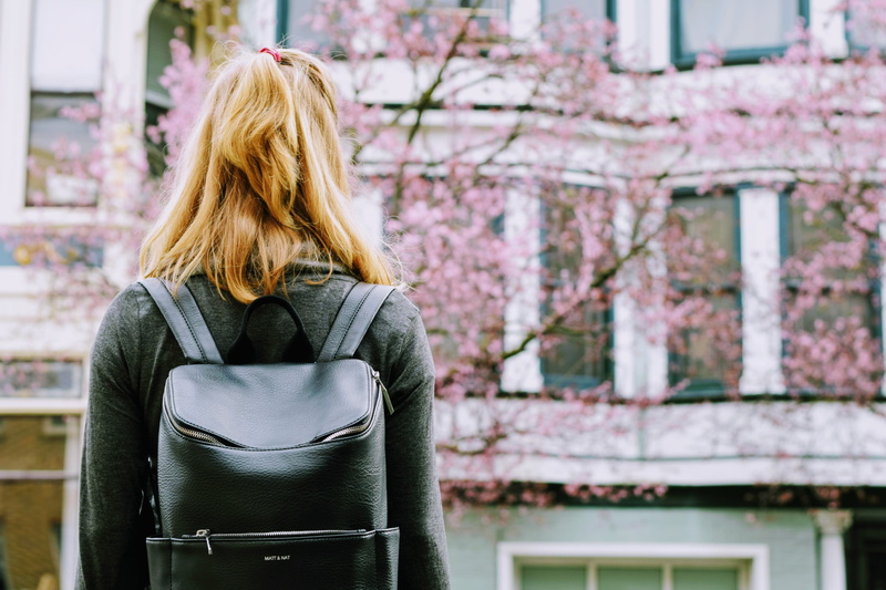 people, real people, cherry blossom, lifestyles, architecture, carrying, street, blond hair, one woman only, leisure activity, woman, city, adult, hairstyle