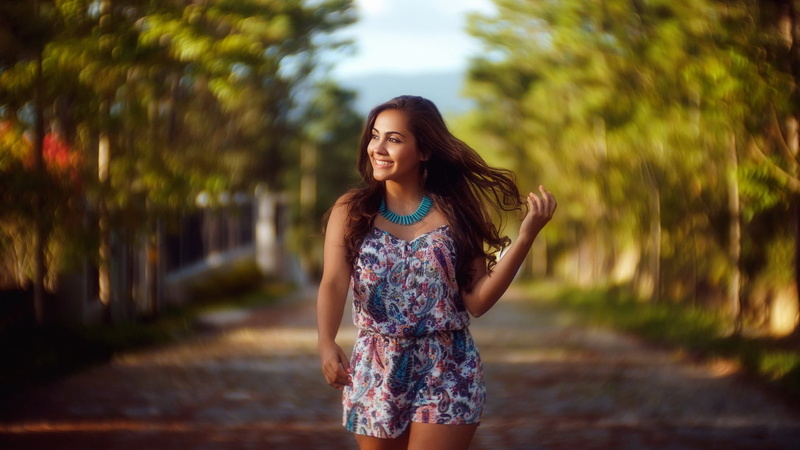 front view, shorts, outdoors, trees, looking away, women outdoors, one person, three quarter length, beautiful woman, young adult, necklace, standing, bare shoulders