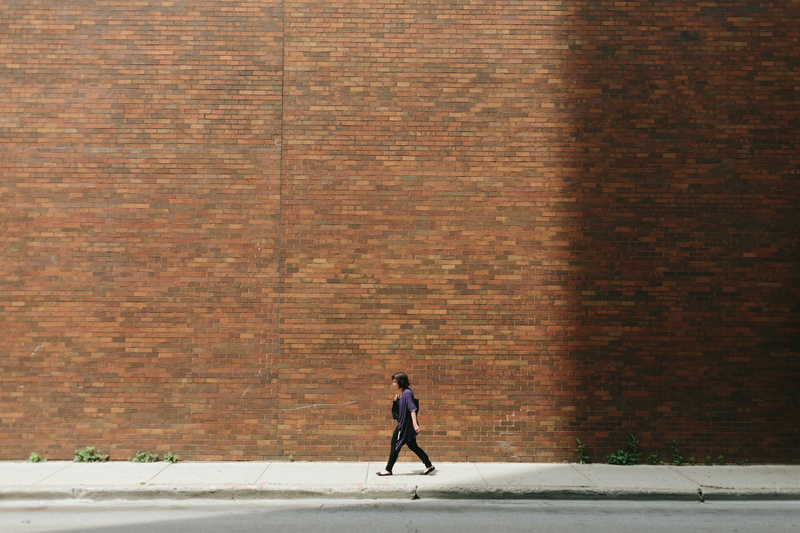 standing, architecture, city, day, brick, brick wall, casual clothing, 5K, red, walking, pavement, one woman only, one person, full length, street, built structure