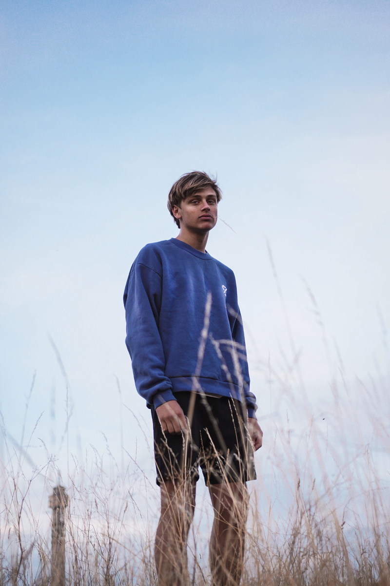 one person, 5K, man, person, contemplation, plant, front view, sweater, day, clear sky, nature, human, field, casual clothing, looking down, leisure activity
